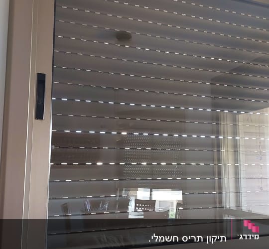 תריסים סגורים על חלון עם מסגרת מתכתית